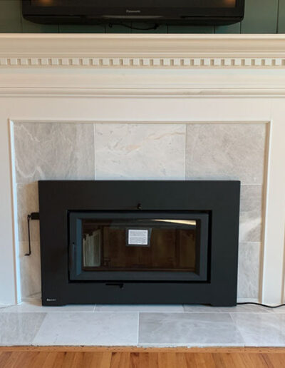 White and gray marble surround with white trim around a fireplace insert